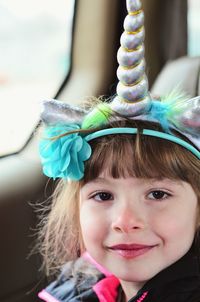 Close-up portrait of smiling girl wearing headwear in car