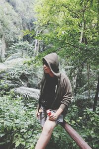 Full length of young man standing in forest
