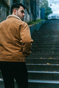 Rear view of man standing on steps