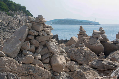 Stack of rocks on beach against sky