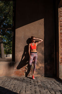 Full length of woman standing against wall