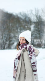 Portrait of young woman standing in snow