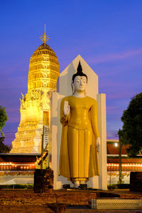 Statue of buddha against building against sky