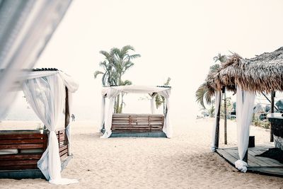 Chairs on beach against clear sky