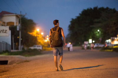 Blurred motion of man walking on road at night