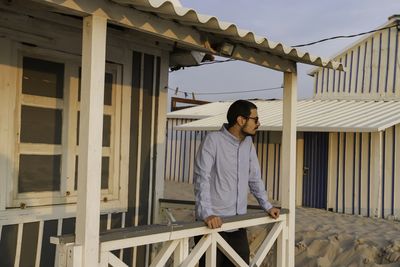 Full length of young man standing against railing