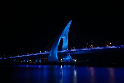 Suspension bridge over river at night