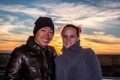Portrait of happy friends against sky during sunset