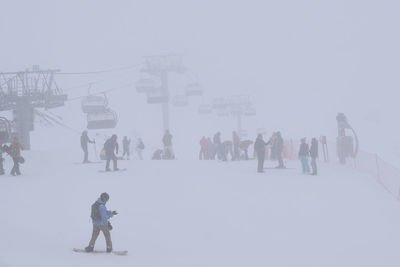 Crowd skiing during snowfall