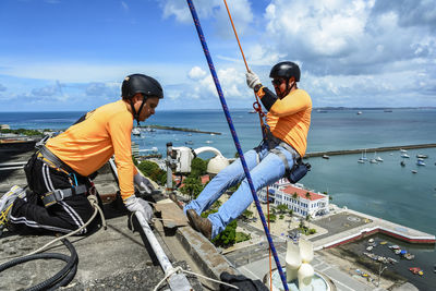 Man with helmet, glove and equipment practicing rappel on elevador lacerda