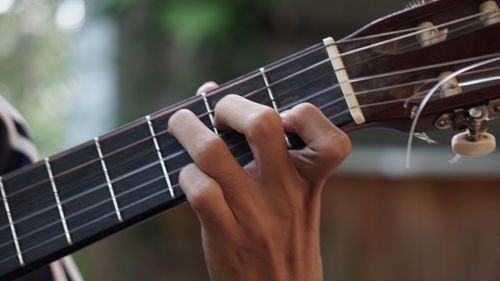 Midsection of man playing guitar