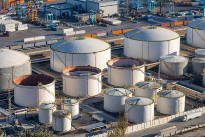 White storage tanks seen in the commercial port of barcelona