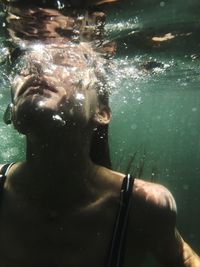 Portrait of shirtless man swimming in pool