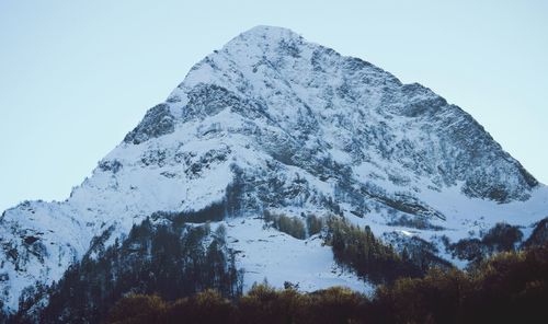 Low angle view of snowcapped mountains against clear sky