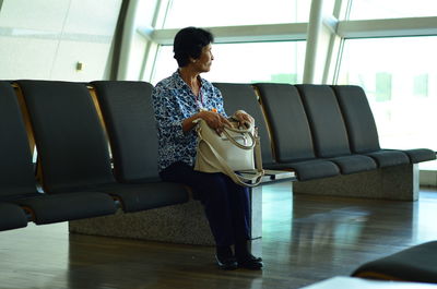Woman using phone while sitting on sofa at home