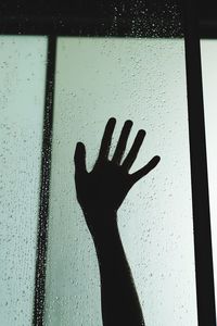 Shadow of person hand on glass window