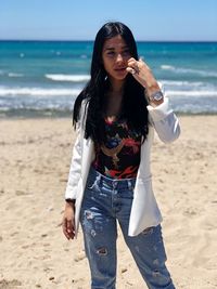 Beautiful young woman standing on beach