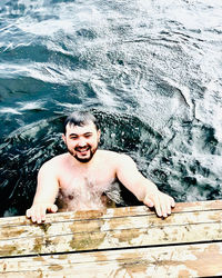 High angle portrait of shirtless man in sea