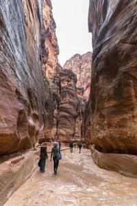 Rear view of people walking on rock