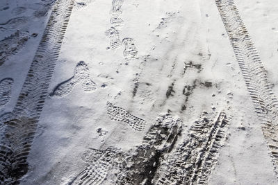 High angle view of tire tracks on snow covered land