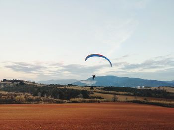 Person paragliding against sky