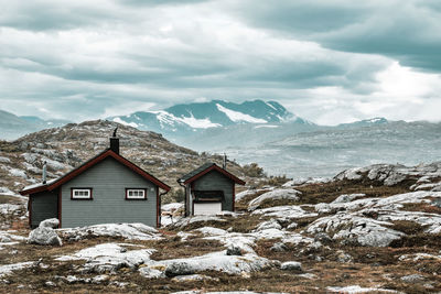 House on land against mountain and sky