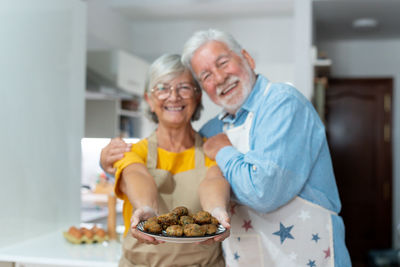 Portrait of young woman with food in kitchen