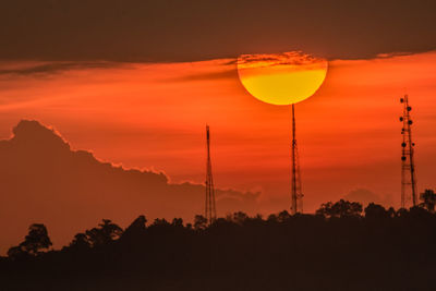 Low angle view of silhouette trees against orange sky