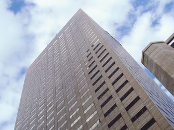 Low angle view of modern building against cloudy sky