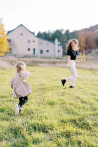 Full length of girl playing with ball on grassy field