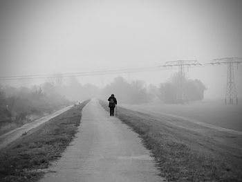 Rear view of person walking on road during winter