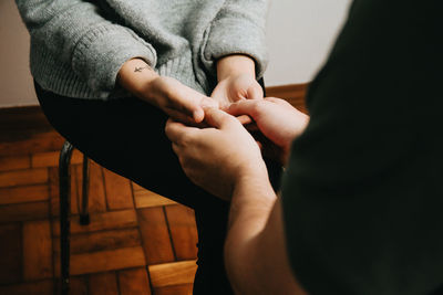 Midsection of psychologist holding hand of patient