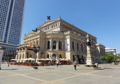 Statue in city against blue sky