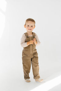 Portrait of boy standing against white background