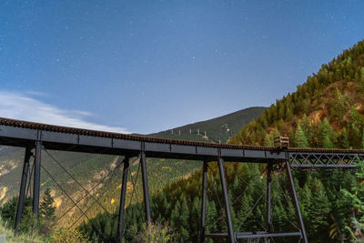 Bridge over mountain against blue sky