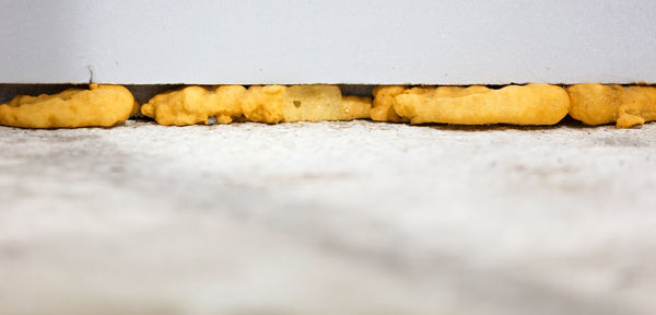 Close-up of bread on table against wall