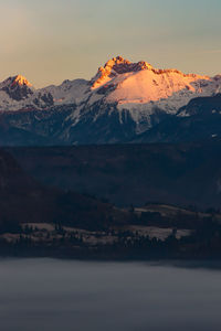 Scenic view of snowcapped mountains against sky during sunset