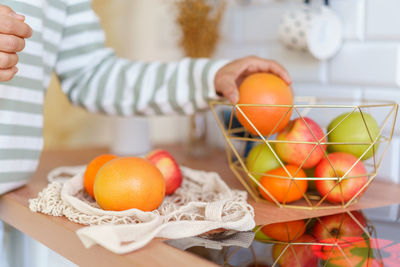 Cropped hand of woman holding easter eggs on table