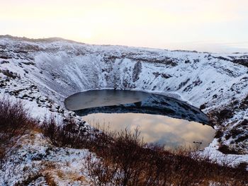 Crater lake and mountain against clear sky during winter