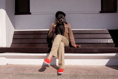 Woman with dog sitting on bench