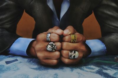 Midsection of man wearing rings at table