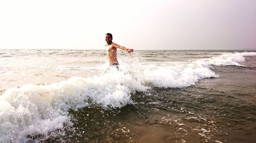 Man surfing in sea against clear sky