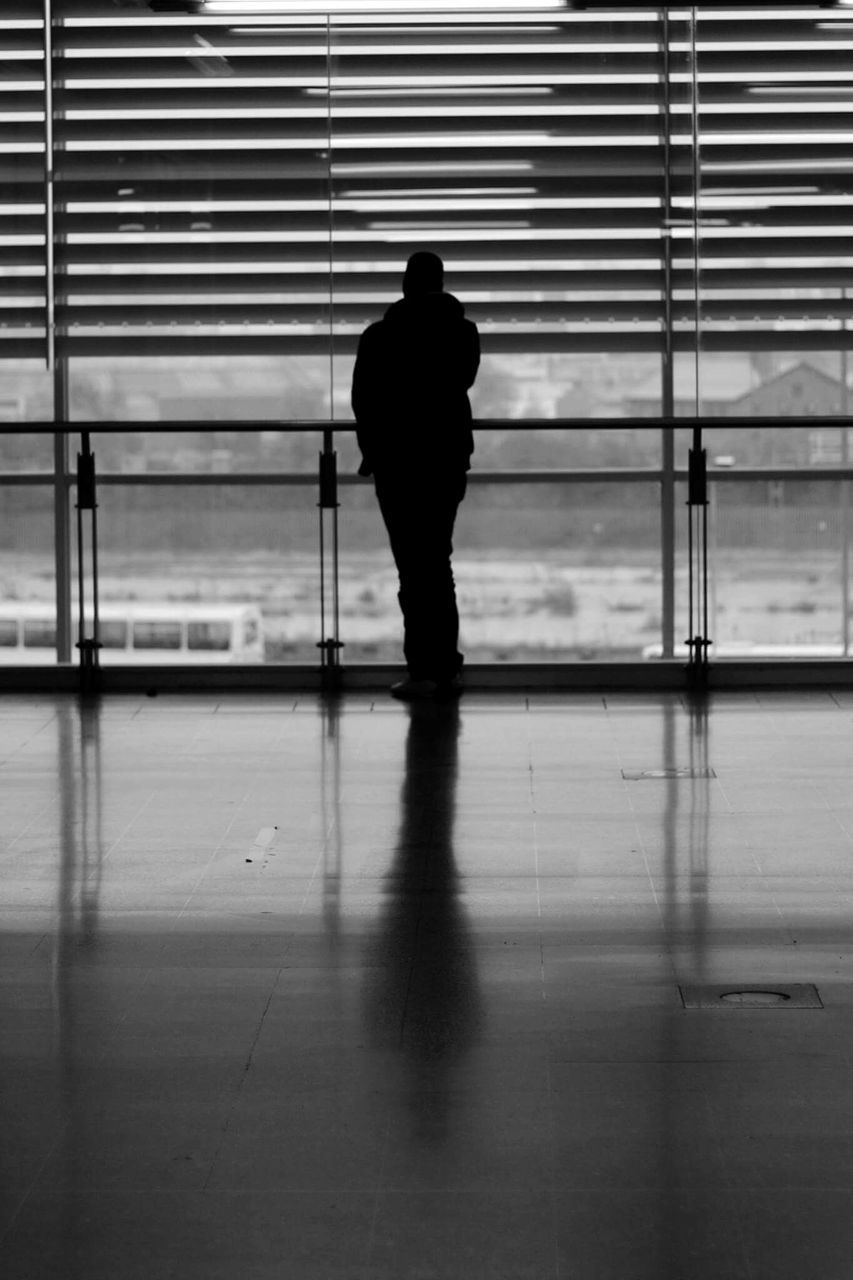 indoors, silhouette, full length, rear view, window, men, glass - material, walking, reflection, lifestyles, standing, person, built structure, architecture, transparent, flooring, leisure activity, side view