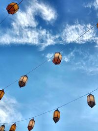 Low angle view of lanterns hanging against sky