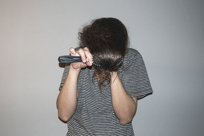 Low section of woman covering groin with christmas decorations over gray background