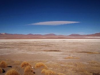 Scenic view of mountains against blue sky