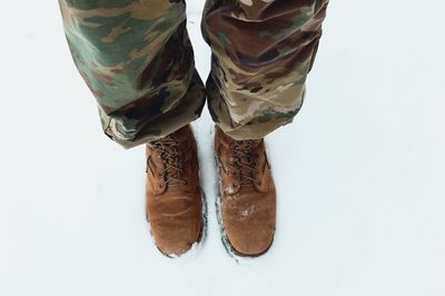 Low section of person standing against white background