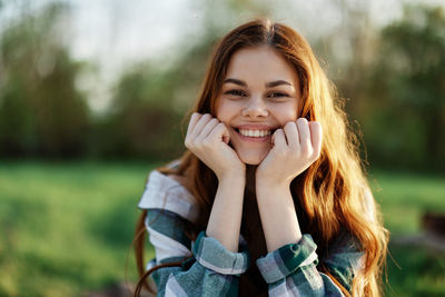 Portrait of young woman sitting on field