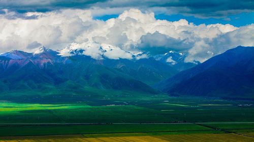 Scenic view of field and mountains against sky