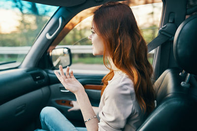 Midsection of woman sitting in car